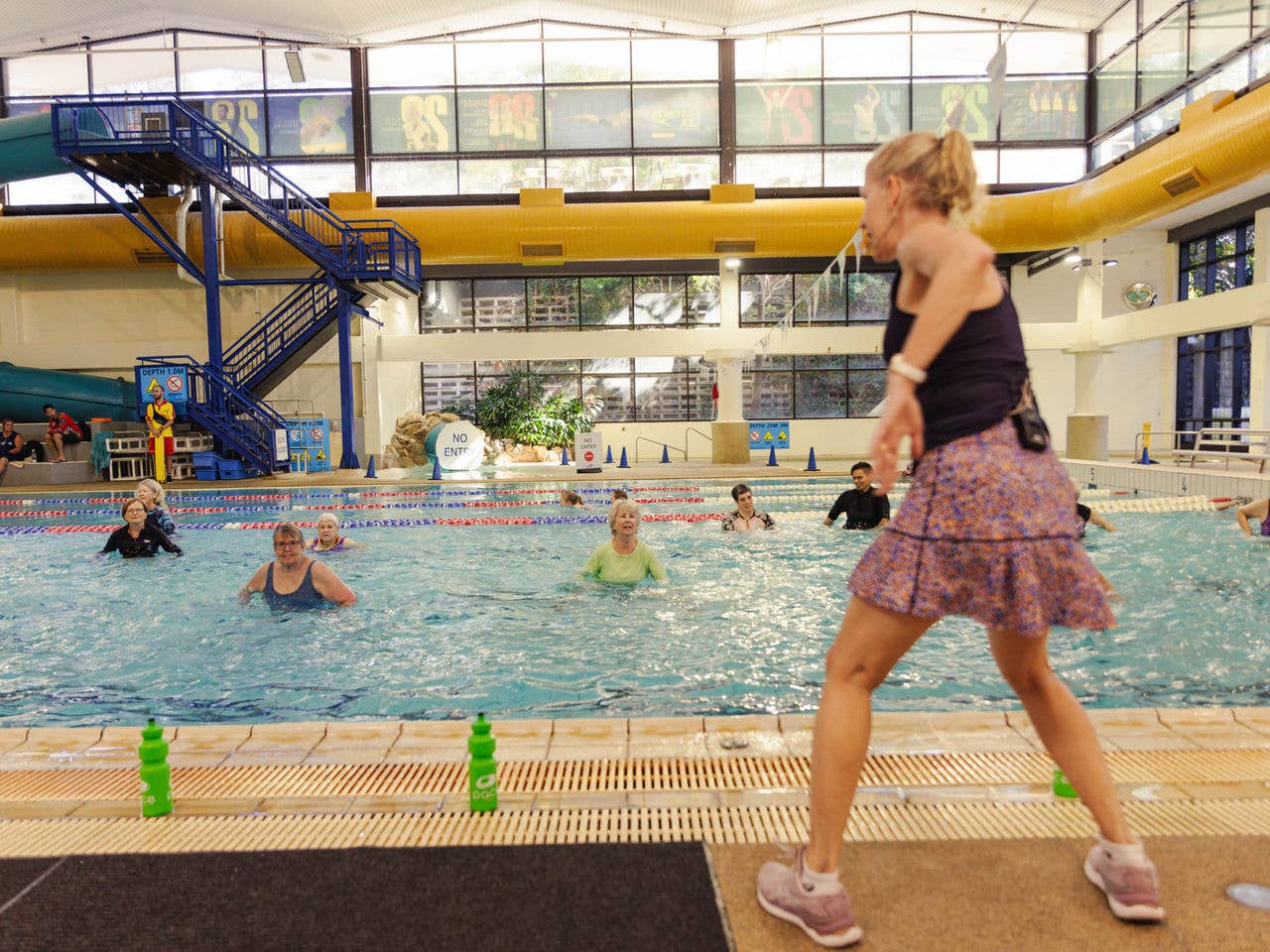 An instructor takes her class through activities in the pool