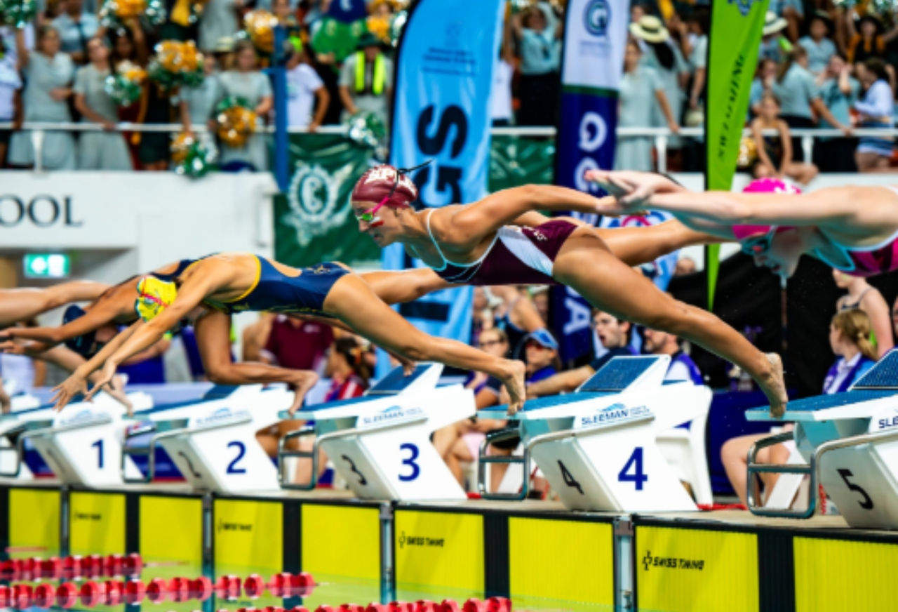 Swimmers diving off the block